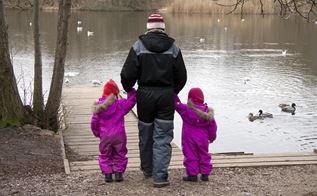 Fotografi af en kvinde med to børn ved en sø